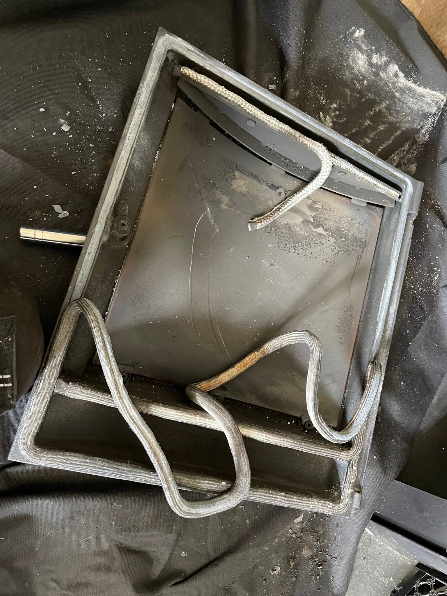 A metal plate from a fireplace laid on the dust sheet