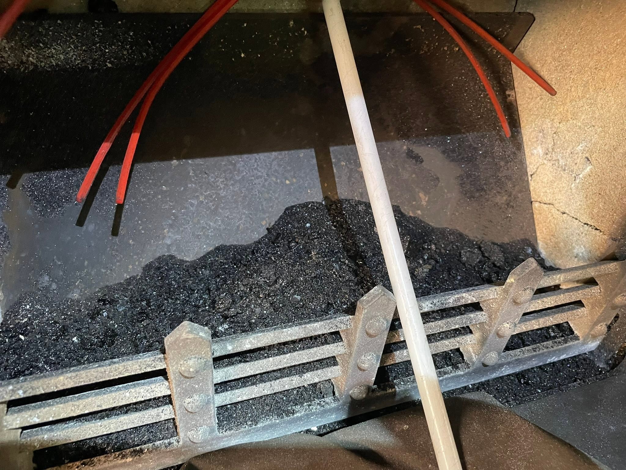 Soot in an open fire grate with sweeping rods in place