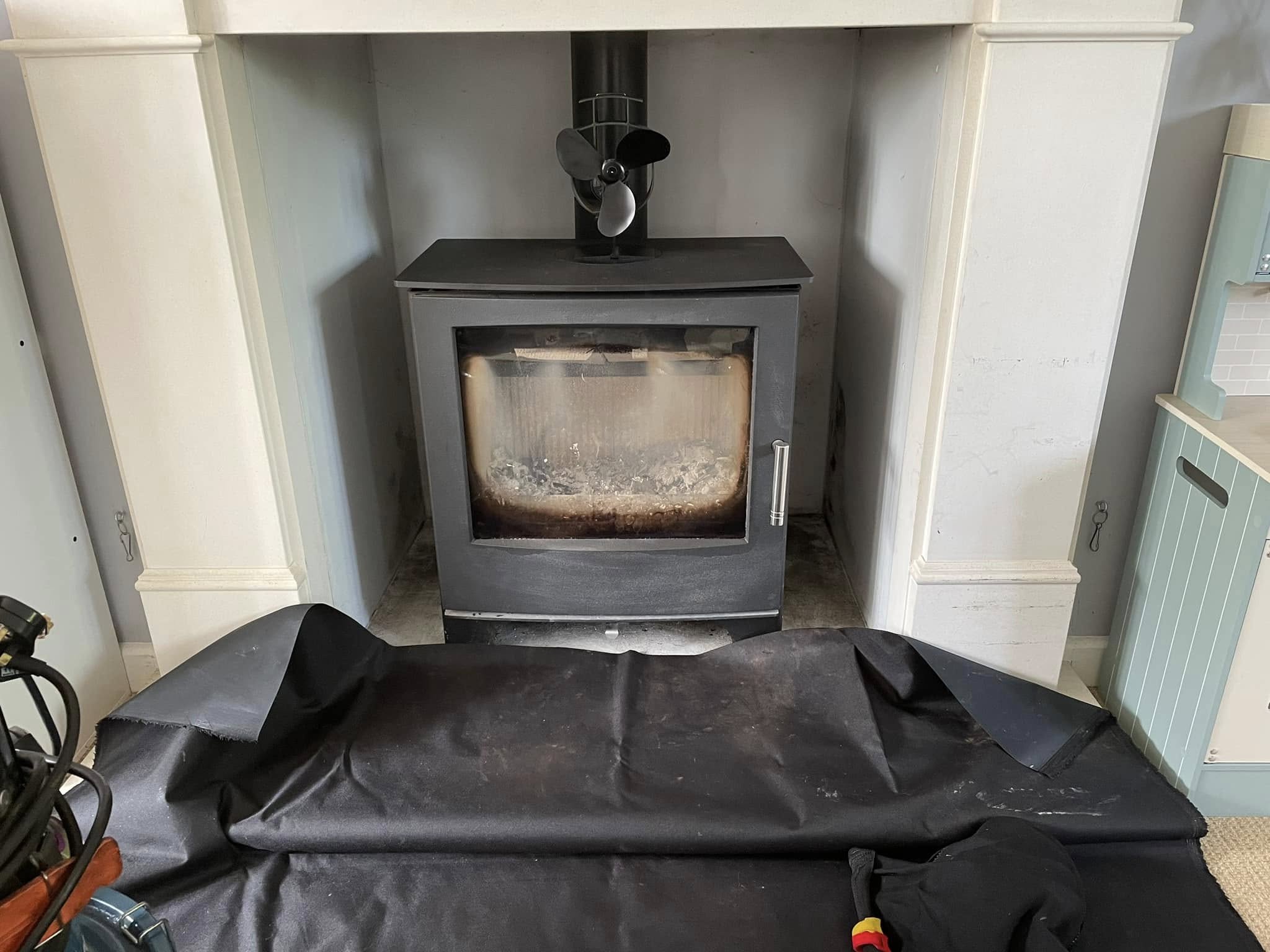 The same stove with a dust sheet laid out in front, ready for sweeping