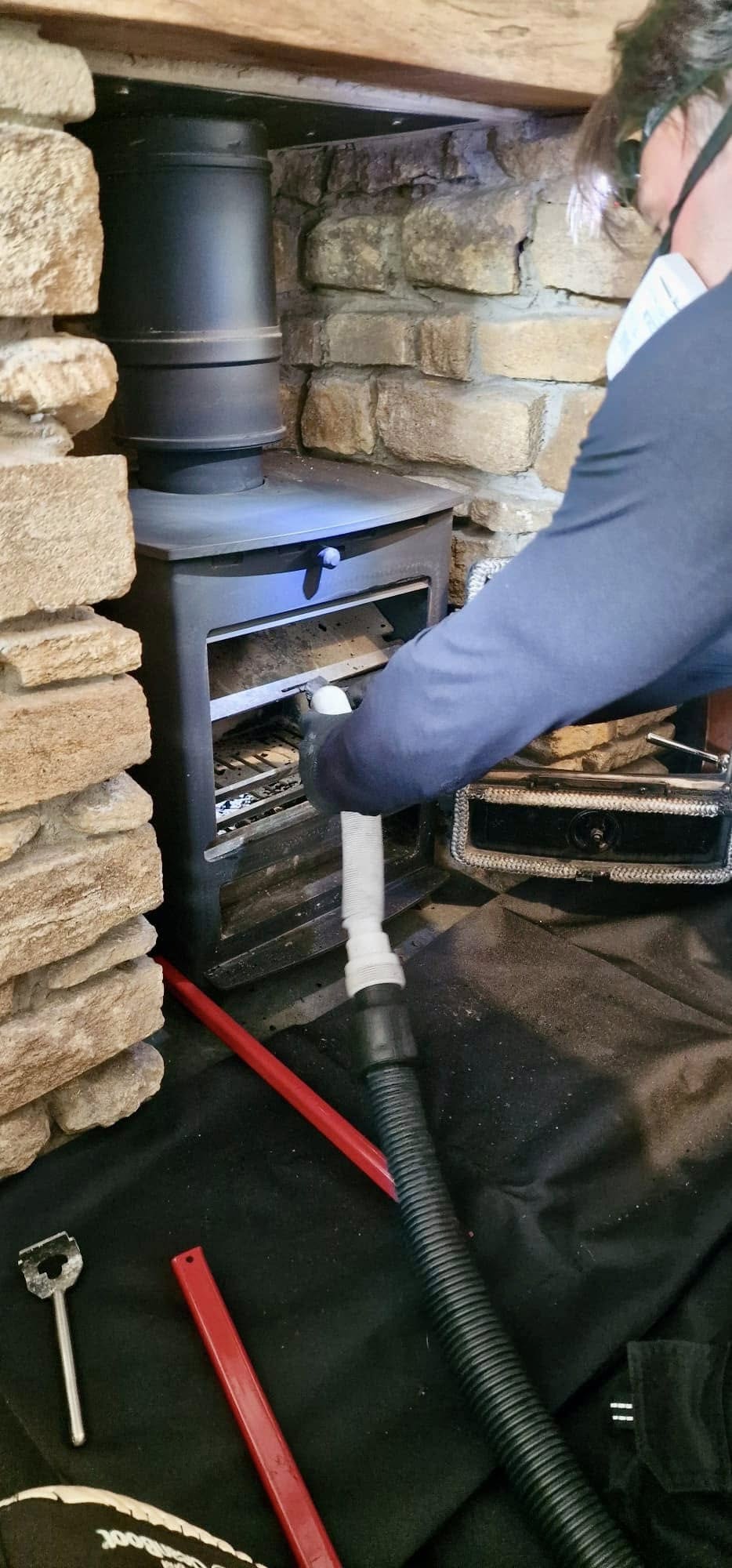 Graham vacuuming out a wood-burning stove