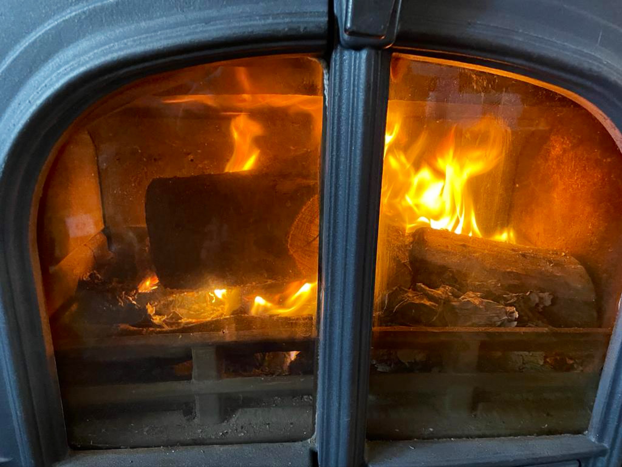 A log burner alight behind its glass doors